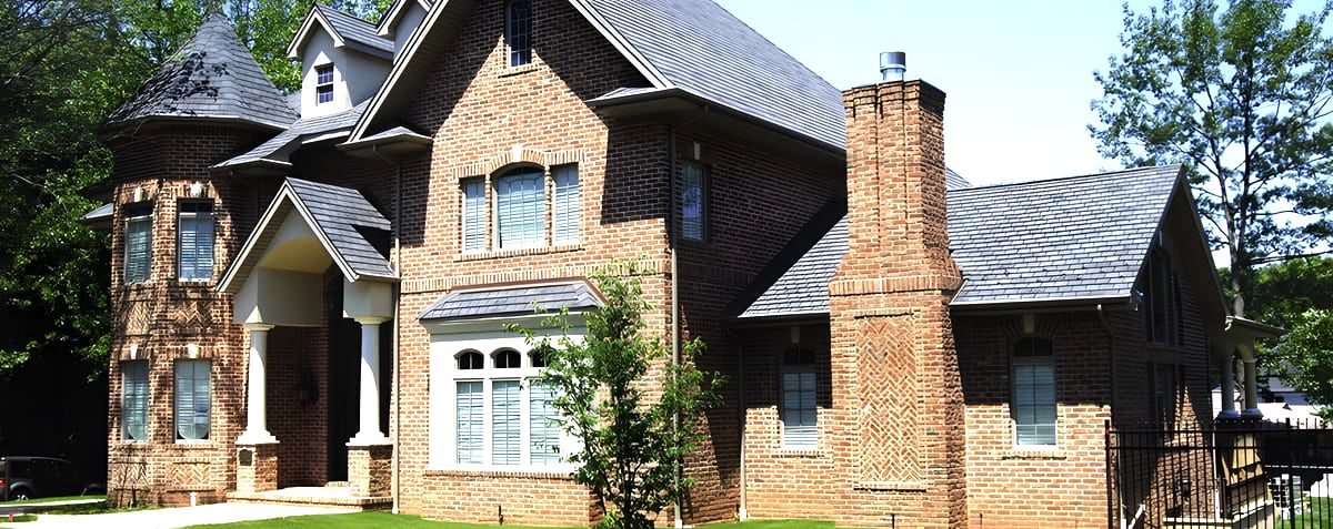 Red brick house with turret, slate roof and herringbone chimney