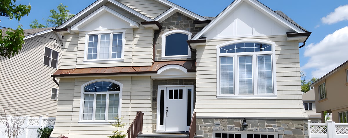 Beige siding house with stone base and arched windows