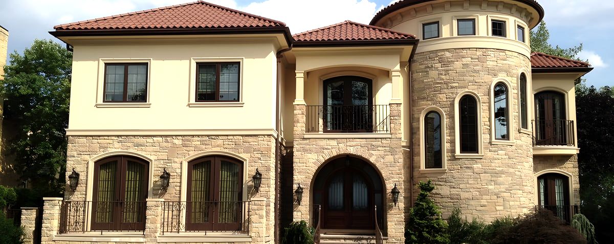 Stucco and stone house with terracotta tile roof and turret